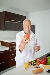 Image showing man cooking at home preparing salad in kitchen