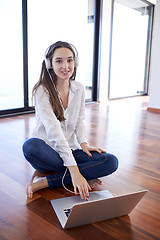 Image showing relaxed young woman at home working on laptop computer