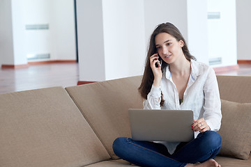 Image showing relaxed young woman at home working on laptop computer