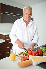 Image showing man cooking at home preparing salad in kitchen