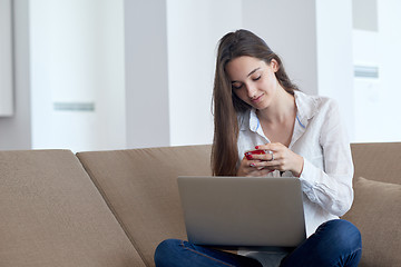 Image showing relaxed young woman at home working on laptop computer