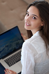 Image showing relaxed young woman at home working on laptop computer