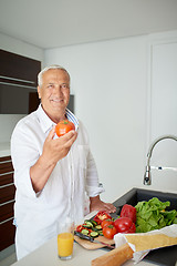 Image showing man cooking at home preparing salad in kitchen