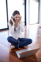 Image showing relaxed young woman at home working on laptop computer