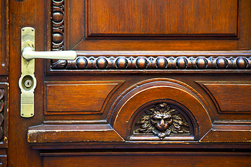 Image showing abstract   brass brown knocker in a   closed wood door    lugano