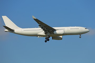 Image showing Plane landing against clear blue sky