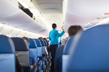 Image showing Interior of airplane with passengers on seats.