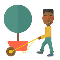 Image showing Young african man pushing the cart with tree.