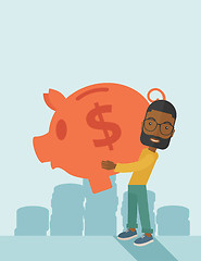 Image showing African businessman carries a big piggy bank for saving money.