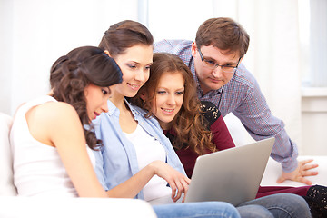 Image showing four students and a notebook