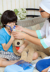 Image showing family doctor spends boy inhalation session