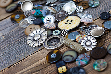 Image showing Vintage buttons in large numbers scattered on aged wooden boards
