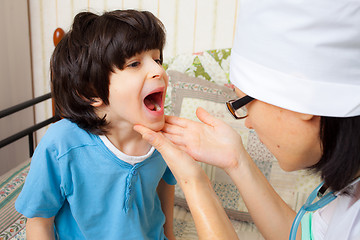 Image showing doctor looks throat of boy