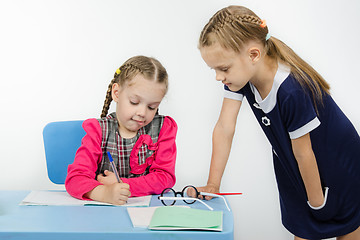 Image showing Teacher student leaning on a table looking notebook