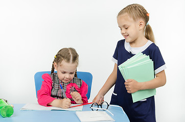 Image showing Girl teacher pointer indicates something in a notebook student