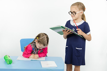 Image showing Girl teacher reading assignment student