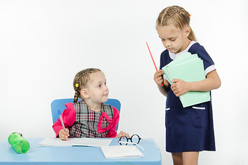 Image showing Teacher seeks pupil notebook pile of notebooks