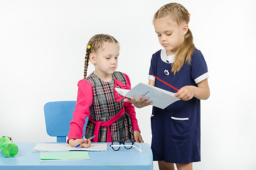 Image showing The teacher looks at pupils diary