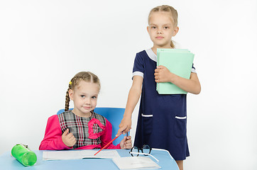 Image showing Girl teacher points at student notebook