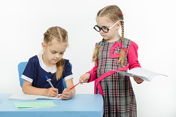 Image showing The teacher points to a pointer in the notebook student