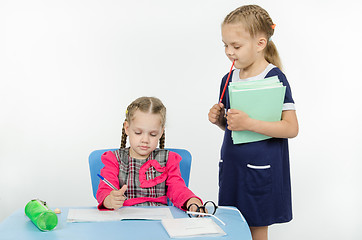 Image showing Girl teacher enthusiastically looking at the notebook student