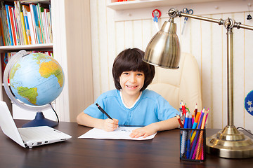 Image showing smiling schoolboy doing homework