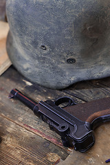 Image showing pistol Parabellum and vintage German soldier helmet