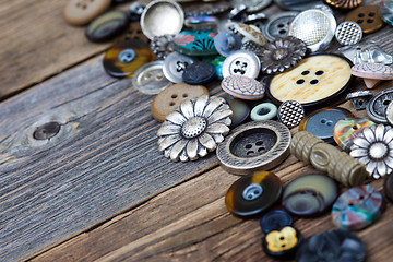 Image showing old buttons in large numbers scattered on aged wooden boards