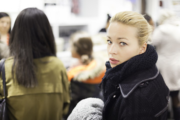 Image showing Female shopper queuing in line at cashier.