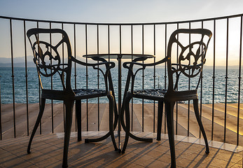 Image showing Terrace lake view with iron chairs and table