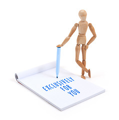 Image showing Wooden mannequin writing in scrapbook - XXXXX