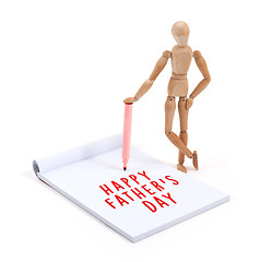 Image showing Wooden mannequin writing in scrapbook - Happy fathers day