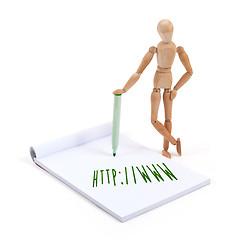 Image showing Wooden mannequin writing in scrapbook - http www