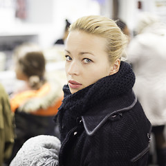 Image showing Female shopper queuing in line at cashier.