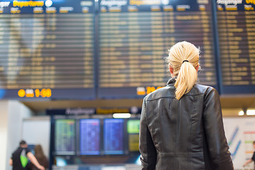 Image showing Female traveller checking flight departures board.