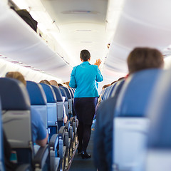 Image showing Interior of airplane with passengers on seats.