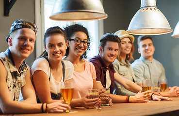 Image showing happy friends drinking beer and cocktails at bar