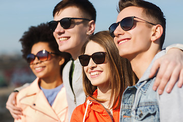 Image showing happy teenage friends in shades hugging outdoors