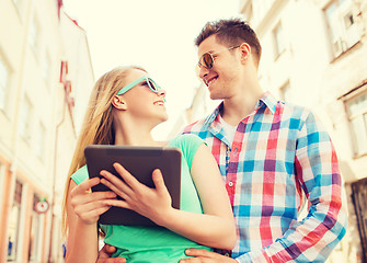 Image showing smiling couple with tablet pc in city