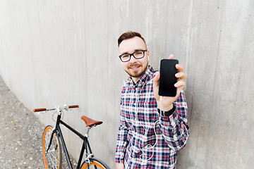 Image showing hipster man in earphones with smartphone and bike