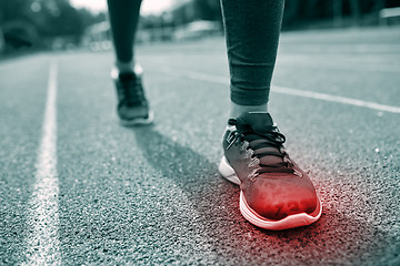 Image showing close up of feet with red spot running on track