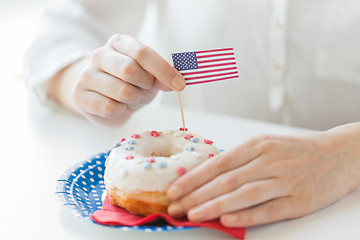 Image showing female hands decorating donut with american flag