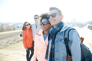 Image showing happy teenage friends in shades hugging on street