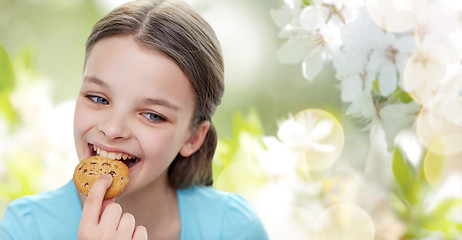 Image showing smiling little girl eating cookie or biscuit