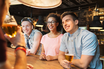 Image showing happy friends drinking beer and talking at bar