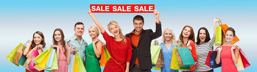 Image showing happy people with red sale sign and shopping bags