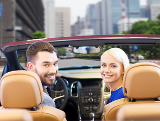 Image showing happy couple driving in cabriolet car over city