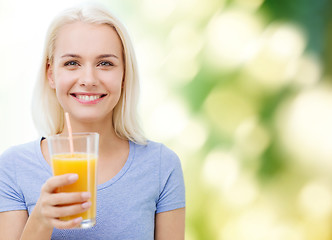 Image showing smiling woman drinking orange juice