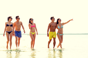 Image showing smiling friends in sunglasses on summer beach