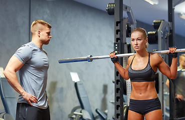 Image showing man and woman with barbell flexing muscles in gym